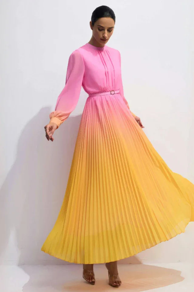 Model wearing a pink to yellow ombre pleated chiffon maxi dress with long sleeves and a belt. Main image