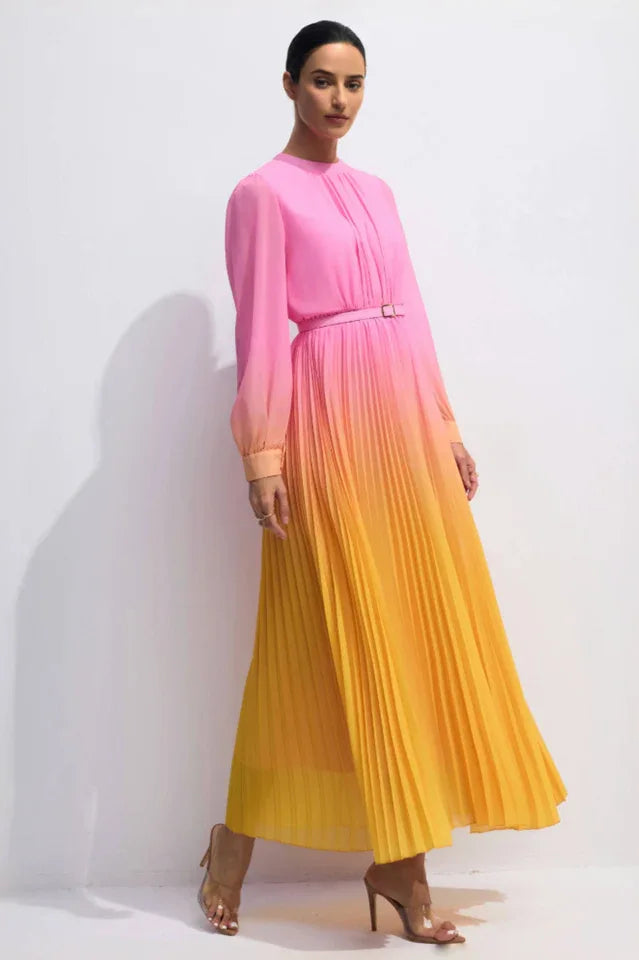 Three-quarter view of a model in a pink to yellow ombre pleated chiffon maxi dress, posing with arms outstretched.