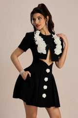 Close-up of the black cropped jacket with white floral embellishments.