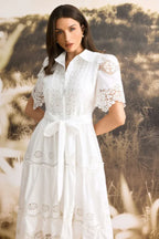 Front view of a woman in a white lace midi dress with a collared neckline and short sleeves.