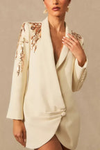 Close-up of the embellished shoulder and neckline of a cream tuxedo dress.