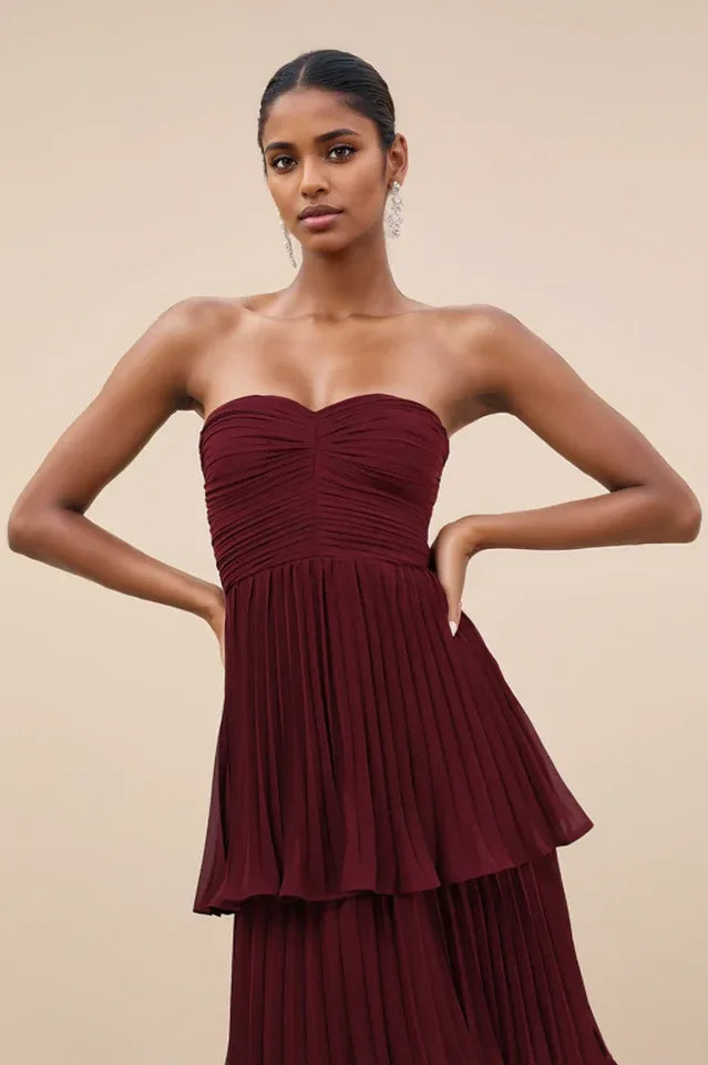 Close-up of the ruched bodice and upper tiers of a burgundy strapless gown Secondary image