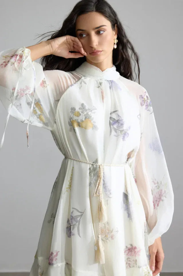 Close-up of the floral print and high neckline of the white chiffon dress. Secondary image