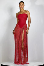 Woman wearing a red strapless gown with fringe detailing and high slits.