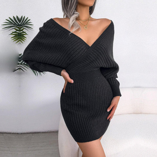 Woman in a charcoal knit dress with a deep V-neck and long sleeves.