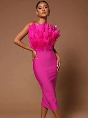 Woman in a hot pink strapless midi dress with a feather-trimmed bodice, posing against a brown background.