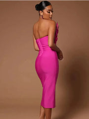 Back view of a woman in a hot pink strapless midi dress with a feather-trimmed bodice.