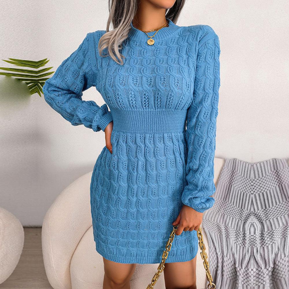 Woman holding a gold chain purse while wearing a blue knit dress.