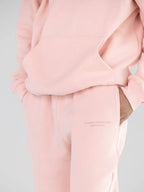 Close-up of the embroidered detail on light pink sweatpants