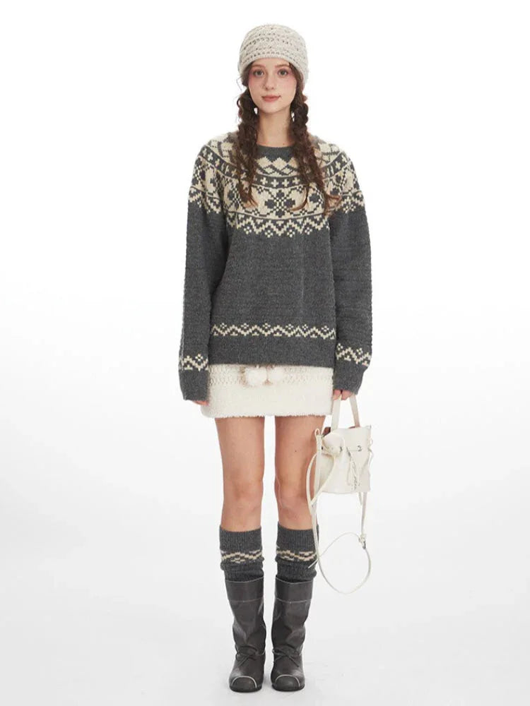 Woman wearing a grey and cream Fair Isle knit sweater, white mini skirt, grey knee-high socks, and black boots, front view
