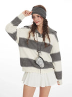 Close-up of a model wearing a striped knit sweater and smiling