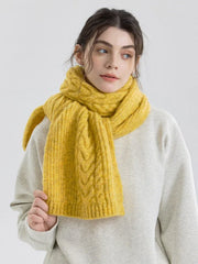 Close-up of a woman wearing a yellow cable knit scarf