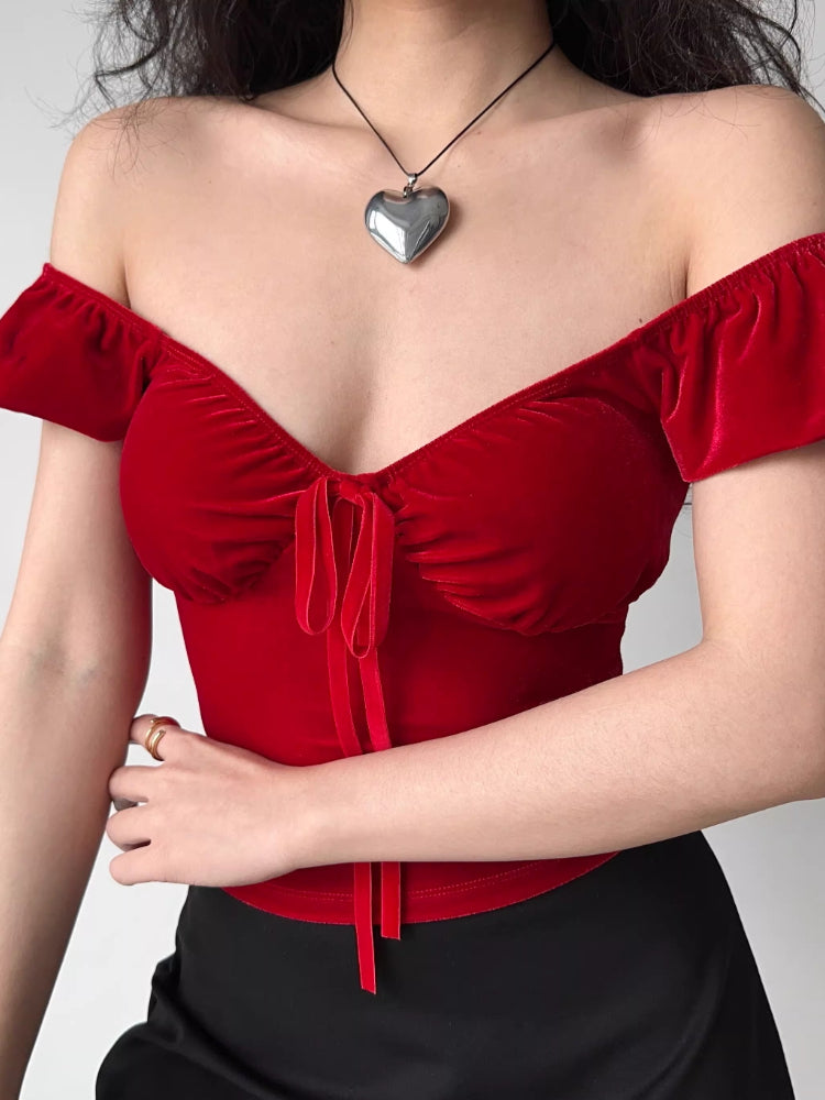 Close-up of a red velvet tie-front top with puff sleeves.