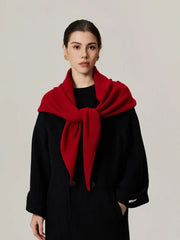 Woman wearing a red scarf tied at the front over a black coat