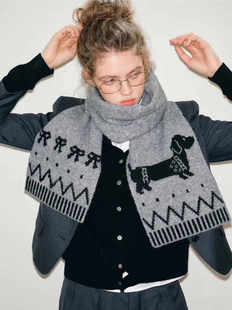 Model wearing a gray knit scarf with a dachshund pattern and zigzag design.