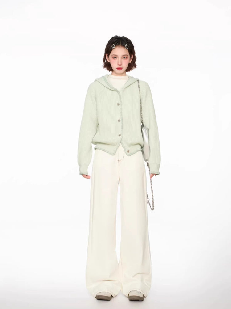 Woman wearing a light green hooded cardigan with white pants and a silver bag, full body front view, slight angle