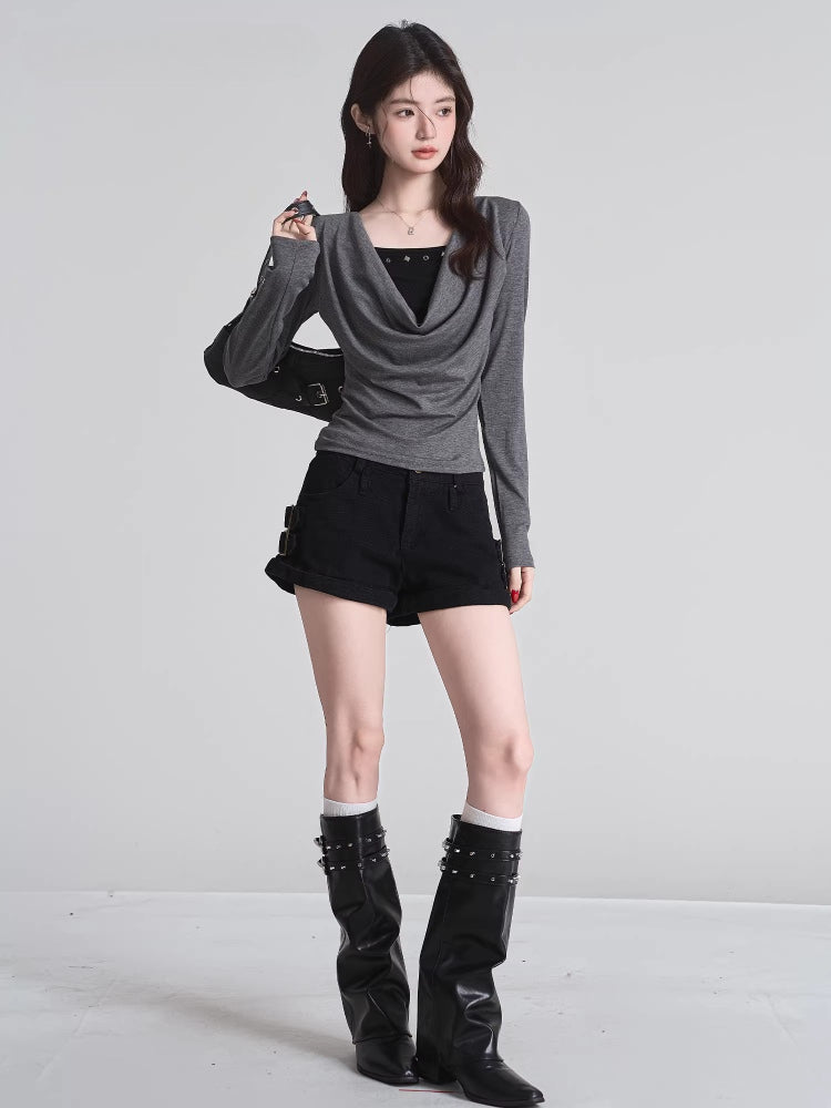 Full-body shot of a model wearing a grey long-sleeved top, black shorts, and black boots.