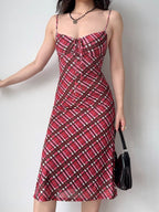 Side view of a woman modeling a red plaid midi dress with a sweetheart neckline and tie detail.