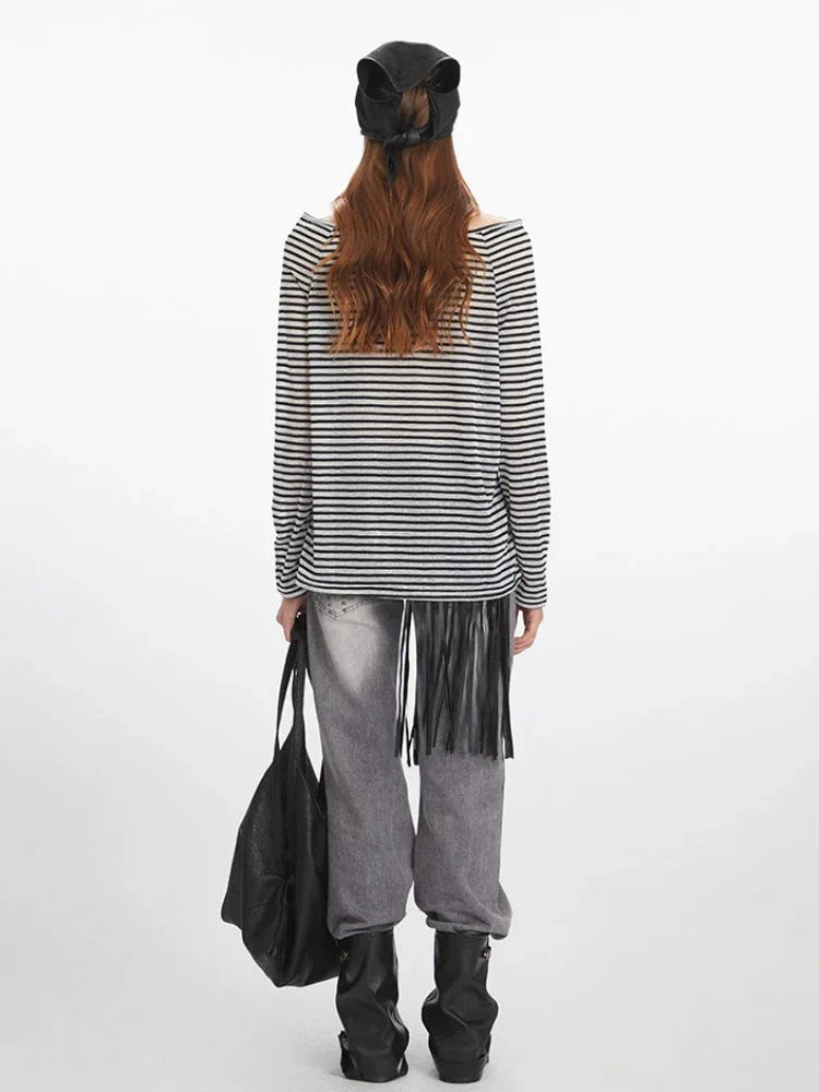 Front view of a woman wearing a black and white striped long-sleeved shirt with an off-the-shoulder neckline.