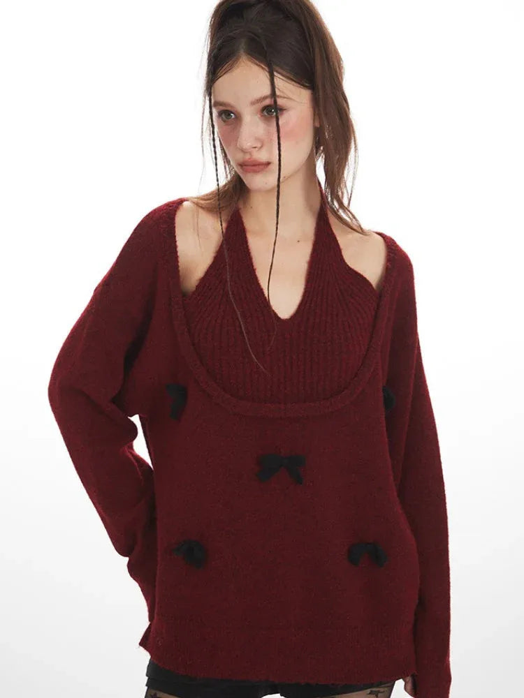 Close-up of a woman wearing a burgundy layered sweater with black bows, black star-patterned tights, and black boots, holding a black handbag.