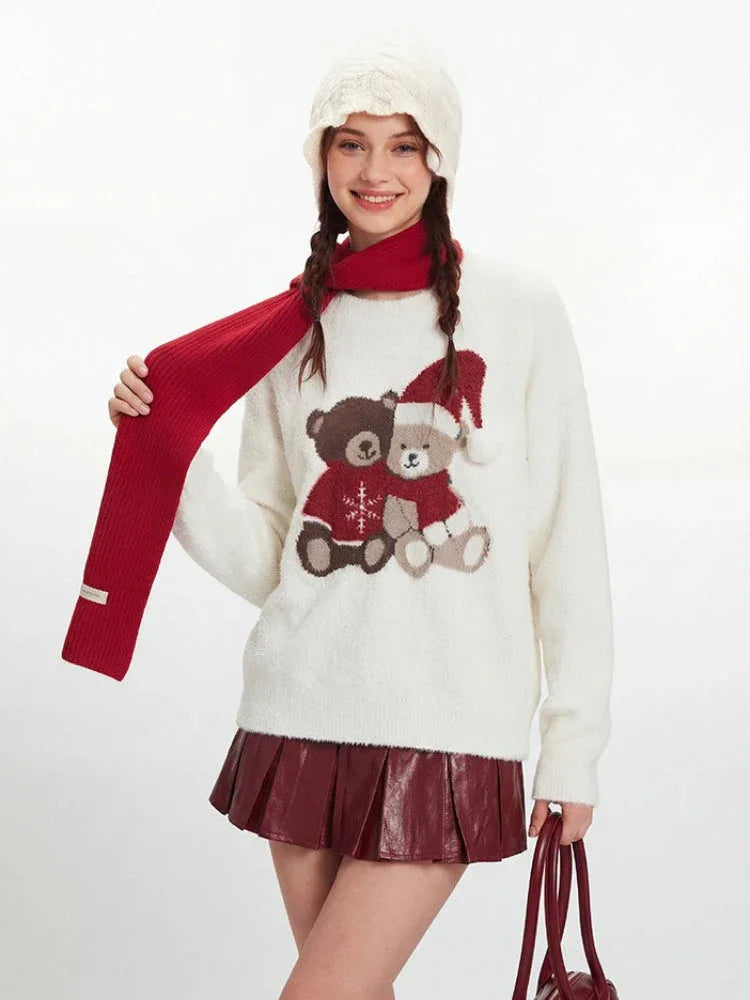 Model adjusting a red scarf worn with a white fuzzy knit sweater featuring a teddy bear graphic.