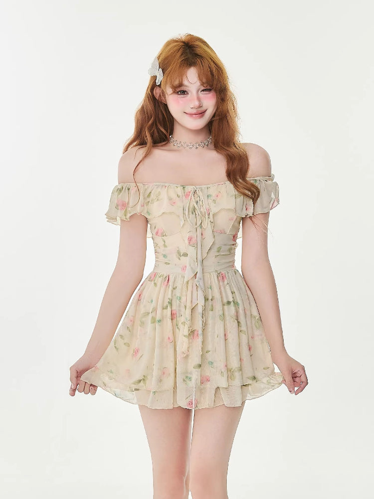 Woman in a floral print mini dress with an off-the-shoulder neckline and tie-front detail, smiling.