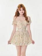 Woman in a floral print mini dress with an off-the-shoulder neckline and tie-front detail, smiling.