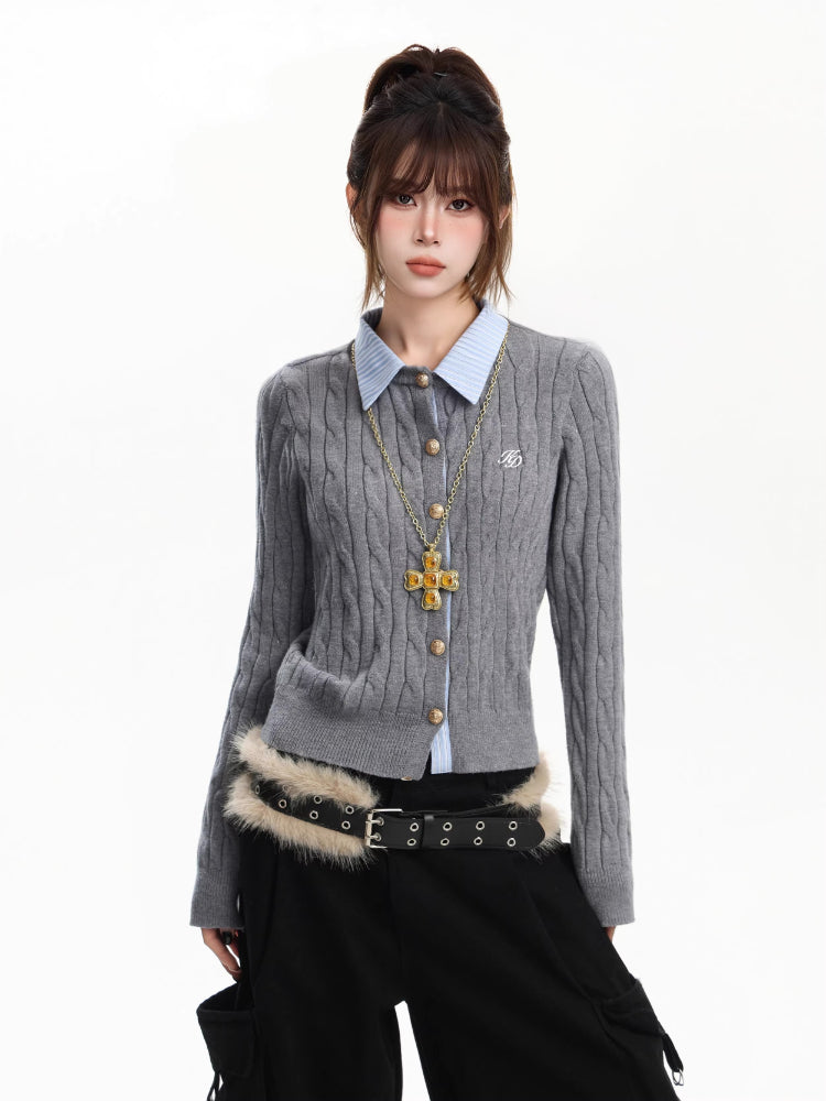 Woman wearing a grey cable knit cardigan with a light blue collared shirt underneath, gold cross necklace, and black cargo pants.