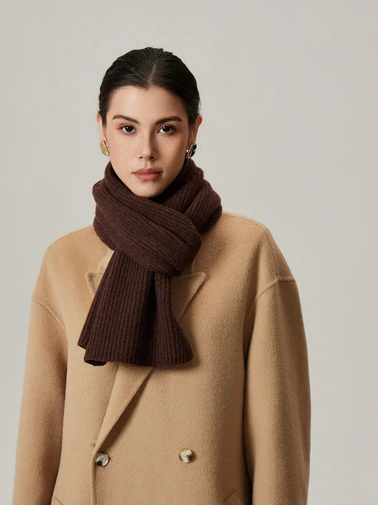 Close-up of a woman wearing a brown ribbed knit scarf.