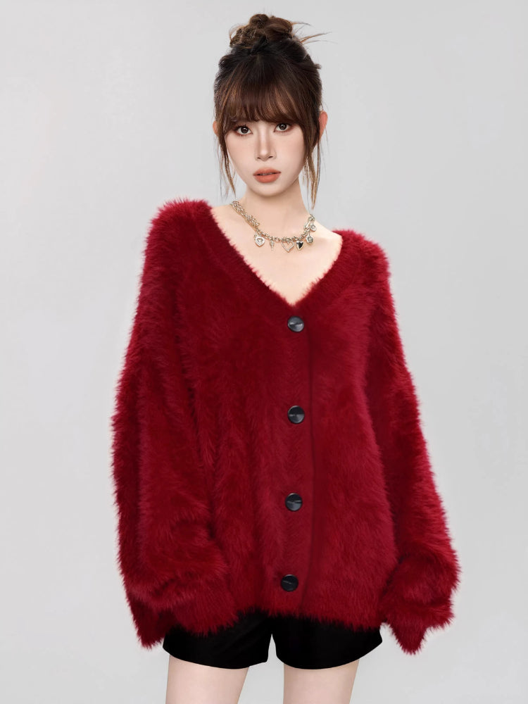 Close-up of a woman wearing a fuzzy red V-neck button-up cardigan.