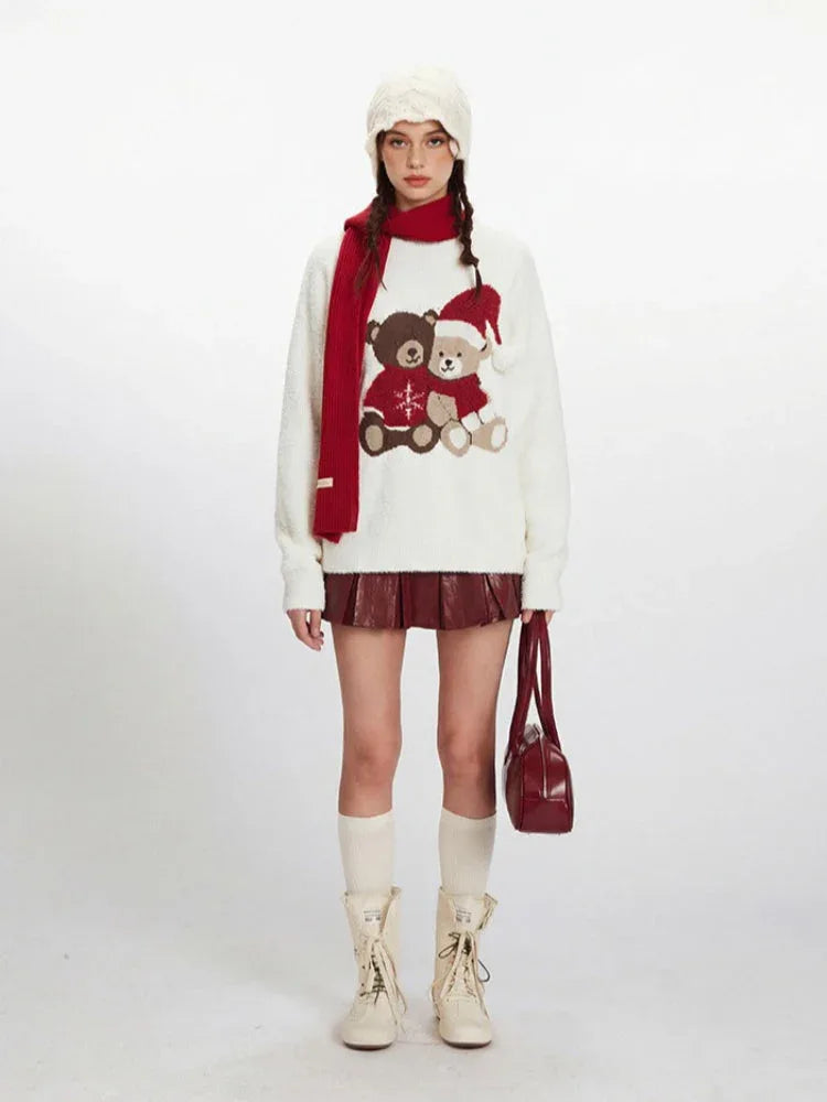Model wearing a white fuzzy knit sweater with a graphic of two teddy bears, a red scarf, white beanie, red pleated skirt, white socks, and cream boots. Main image