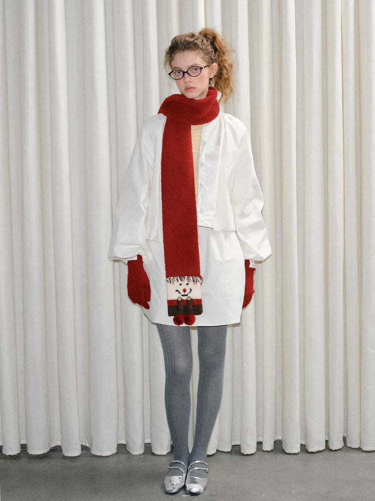 Model wearing a red scarf with a snowman design, red gloves, white jacket, and grey tights.