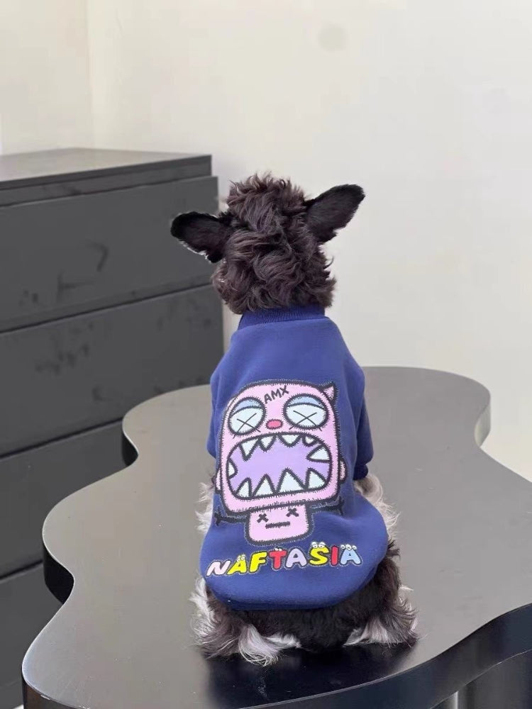 Back view of a Mini Schnauzer puppy wearing a navy blue sweatshirt with a purple monster graphic on the back and the word 'NAFTASIA' below it.