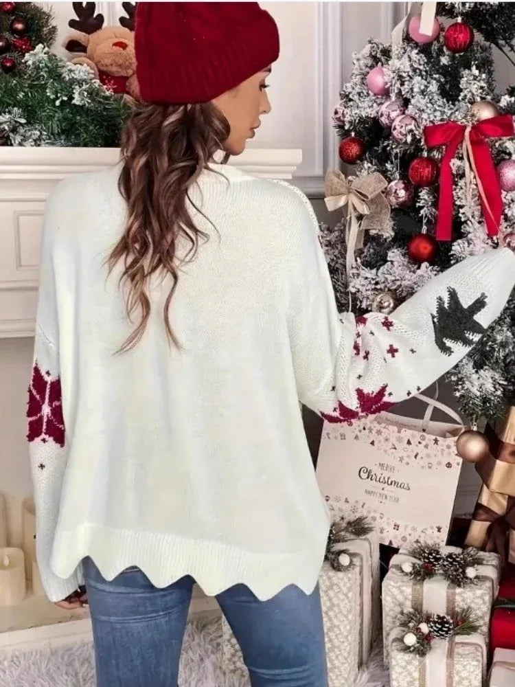 Back view of a woman wearing a white knitted sweater with a Christmas tree and snowflake print, standing in front of a Christmas tree.
