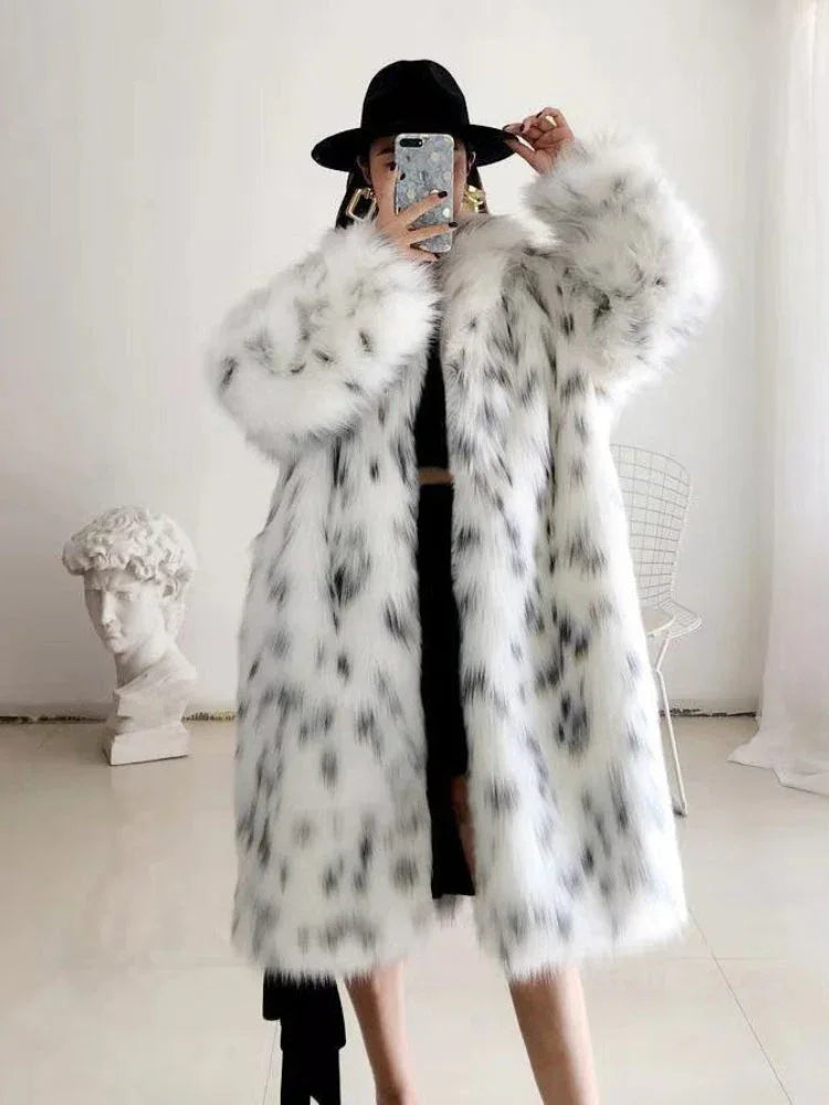 Close-up of a person wearing a spotted faux fur coat and a black hat, holding a phone for a mirror selfie.