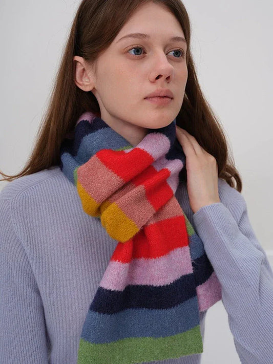 Close-up of a woman wearing a blue sweater and a colorful striped scarf