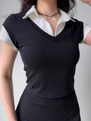 Close-up of a black v-neck top layered over a white collared shirt, showing the ribbed texture and contrasting elements.