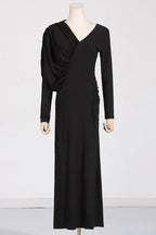 A long-sleeved black dress with asymmetrical draping and ruching, displayed on a mannequin.