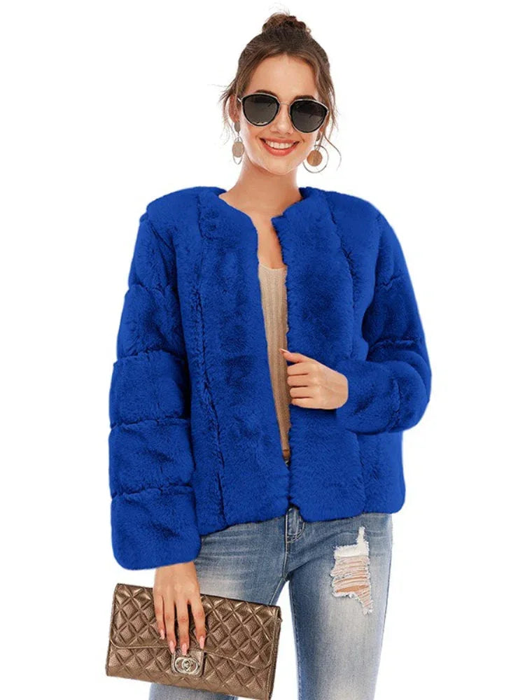 Woman wearing a royal blue faux fur jacket over a light-colored top and ripped jeans, holding a gold clutch.