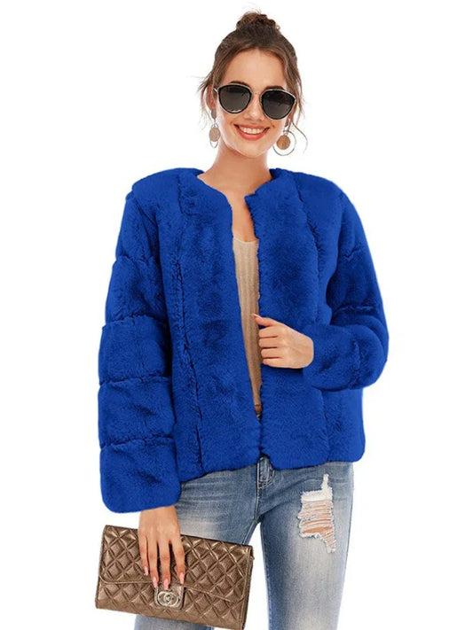 Woman wearing a royal blue faux fur jacket over a light-colored top and ripped jeans, holding a gold clutch.