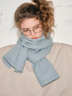 Another close-up of the model's face and upper body, with the light blue scarf draped around her.