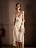 Full-length view of a woman in a cream satin slip dress with lace trim and a matching robe, standing.