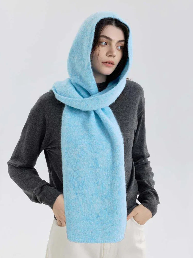 Model wearing a gray sweater with a light blue hooded scarf wrapped around her neck and hood up.