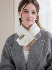 Woman wearing a white top and a tan and white striped scarf