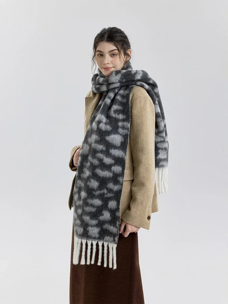 Side profile of a woman wearing a tan blazer and a leopard print scarf