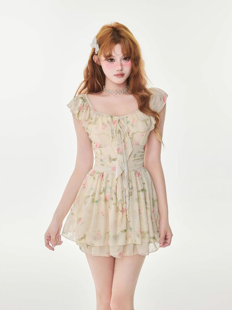 Woman wearing a floral print a-line mini dress with ruffle trim and tie-front detail.