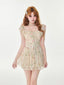 Woman wearing a floral print a-line mini dress with ruffle trim and tie-front detail.