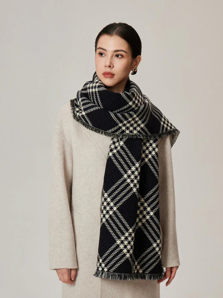 Woman wearing a cream coat and a black and white tartan scarf