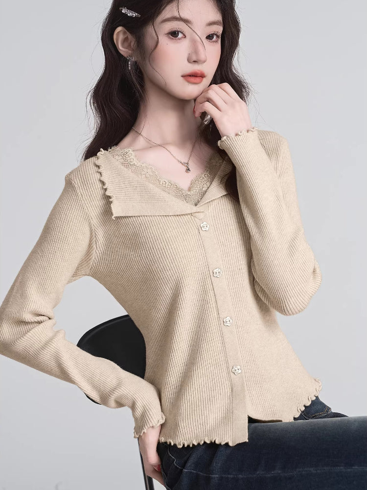 Woman sitting and wearing a beige ribbed knit cardigan with lace trim and a V-neck.