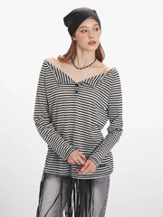 Detail of the lower hem of the striped long-sleeved shirt with a small brand tag.